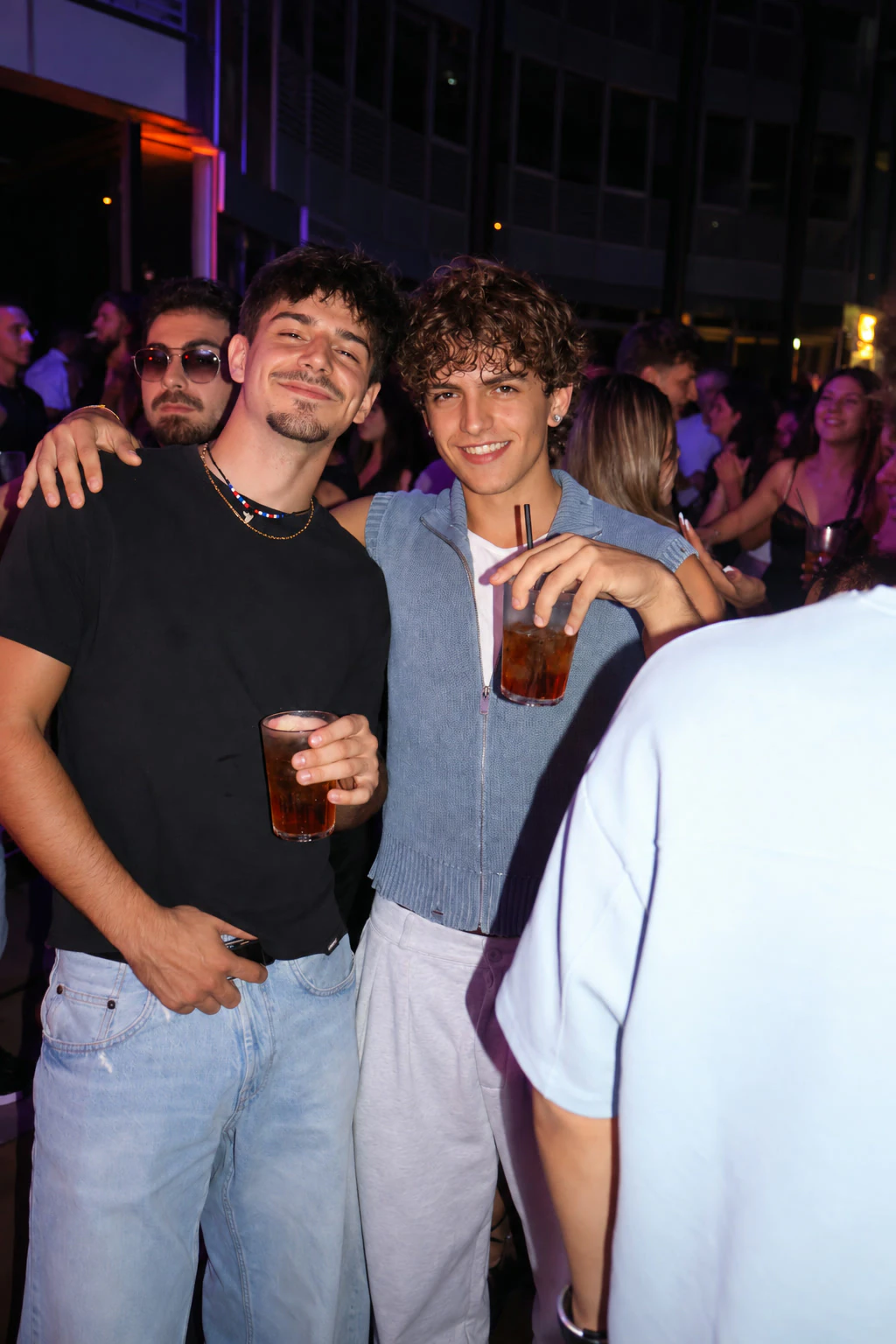 Two friends with drinks, smiling at the camera